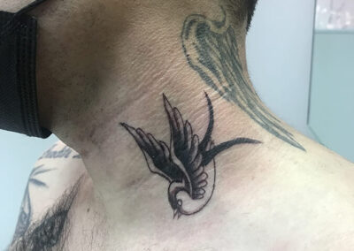 Tattoo de una golondrina en el cuello