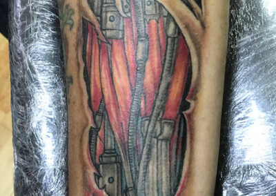 Tattoo en el brazo mitad máquina mitad humano