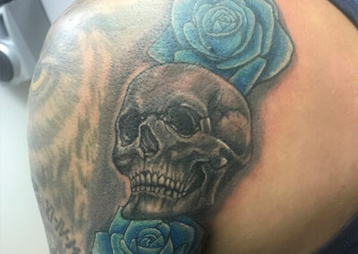 Tattoo en el hombro de calavera con flores